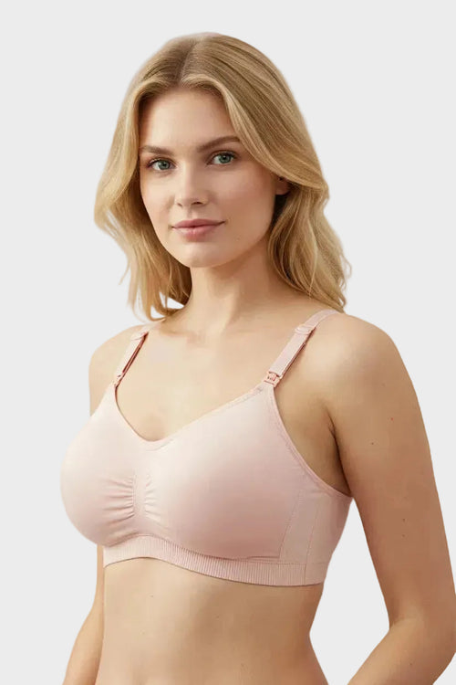 Woman wearing a pink nursing bra holding a baby, with text highlighting features like expansion space and ribbed construction.