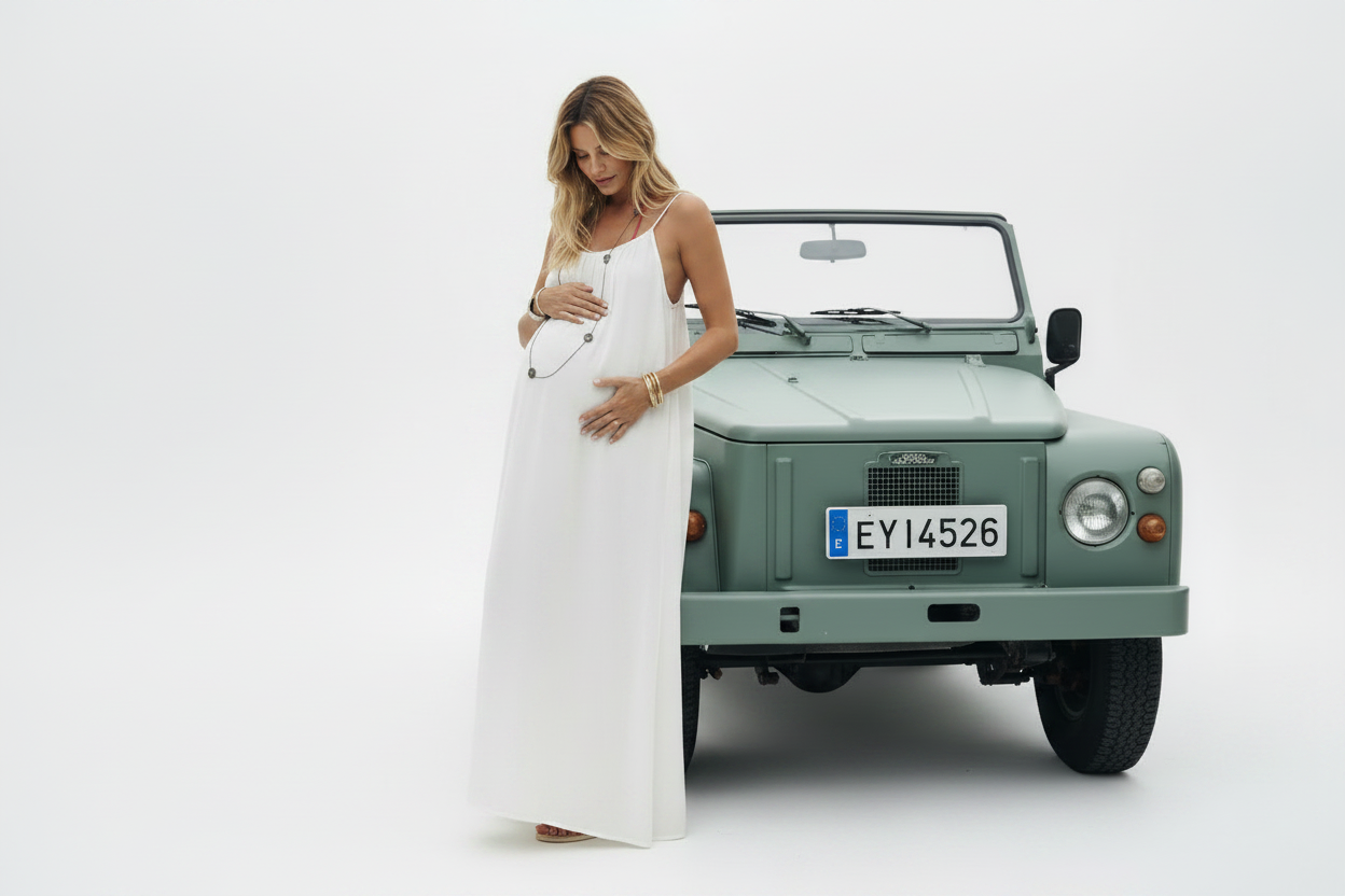 Pregnant model rubbing belly in white maxi dress