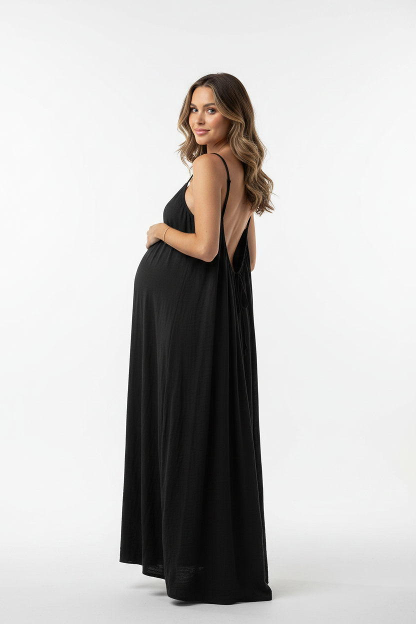 Pregnant model showing backless black dress in studio - portrait